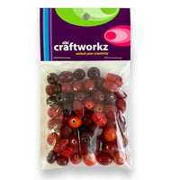A 50 gram pack of assorted glass beads in a red colour mix by Craftworkz. Made in India.