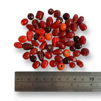 Assorted glass beads in a red colour mix by Craftworkz. Made in India.