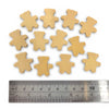 Wooden bear-shaped cutouts with a ruler for scale on a white background