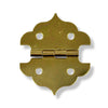 A small brass hinge with a decorative curved shape with a drop shadow on a white background