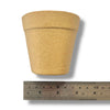 A natural Kraft paper mache half pot with a ruler for scale on a white background