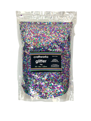 A clear plastic bag filled with multicolored chunky glitter, labelled 'craftworkz glitter 1kg'.