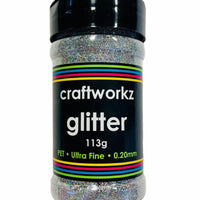 A shaker jar containing ultra fine silver holographic glitter, with label indicating the brand, weight, and characteristics of the glitter.